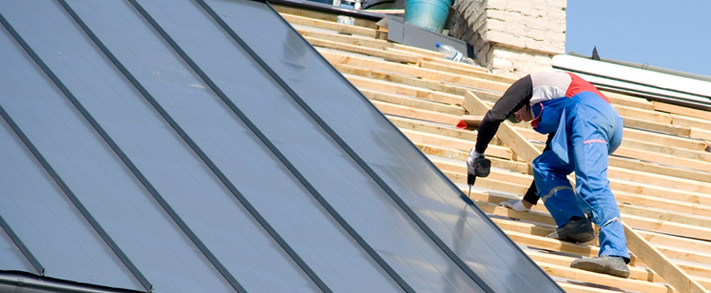 Roofers installing a standing seam metal roof